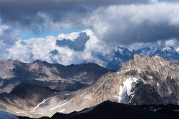 mountain landscape, rocks and glaciers among clouds