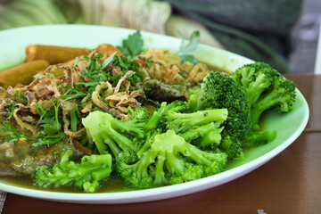 A white plate of freshly cooked, steamed broccoli, vibrant green and ready to eat, offering a healthy, nutritious meal perfect for clean eating and wellness.
