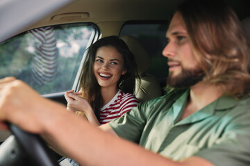 Couple enjoying a fun moment inside a car with a scenic background