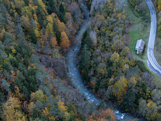 Aerial view of mountain road through a forest in autumn. Aragonese Pyrenees. Huesca. Spain