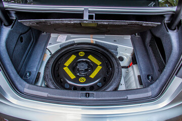 Fixed spare tire in the trunk of a gray car
