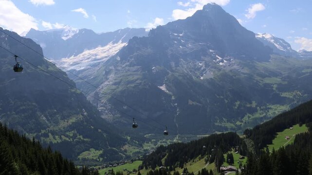 Cable cars ascending up the cable in Swiss alps, Grindelwald valley