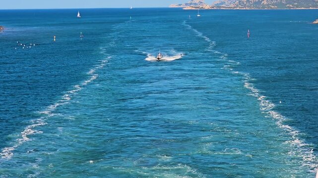 The pilot's boat follows the ship in its wake ready to join it on the port side
