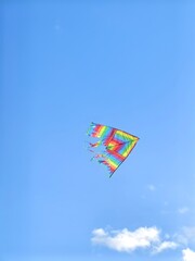 Kite flying in the sky. Bright rainbow kite flying high in the sky.