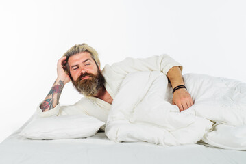 Morning and wake up. Bearded man in bathrobe sleeping in bed. Morning awaking. People, bedtime and rest concept - man lying in bed at home. Good morning. Handsome guy waking up in bedroom at home.