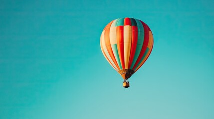 Obraz premium A single hot air balloon ascends into a clear, boundless sky, representing exploration and the joy of flight.