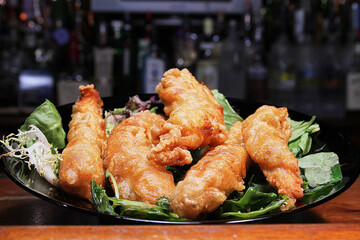 crispy fried chicken tenders on a bed of mixed greens
