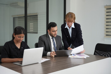 Diverse office colleagues laughing together during a meeting