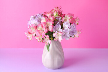 Beautiful alstroemeria flowers in vase on color background