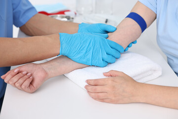Obraz premium Nurse inputting catheter for IV drip in patient hand, closeup