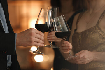 Women and man clinking glasses of tasty wine at party, closeup
