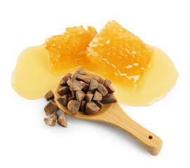 Sweet honeycombs and spoon with propolis granules isolated on white