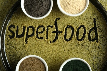 Word Superfood and different healthy powders on table, top view