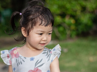 Happy asian toddler enjoying outdoor playtime in park