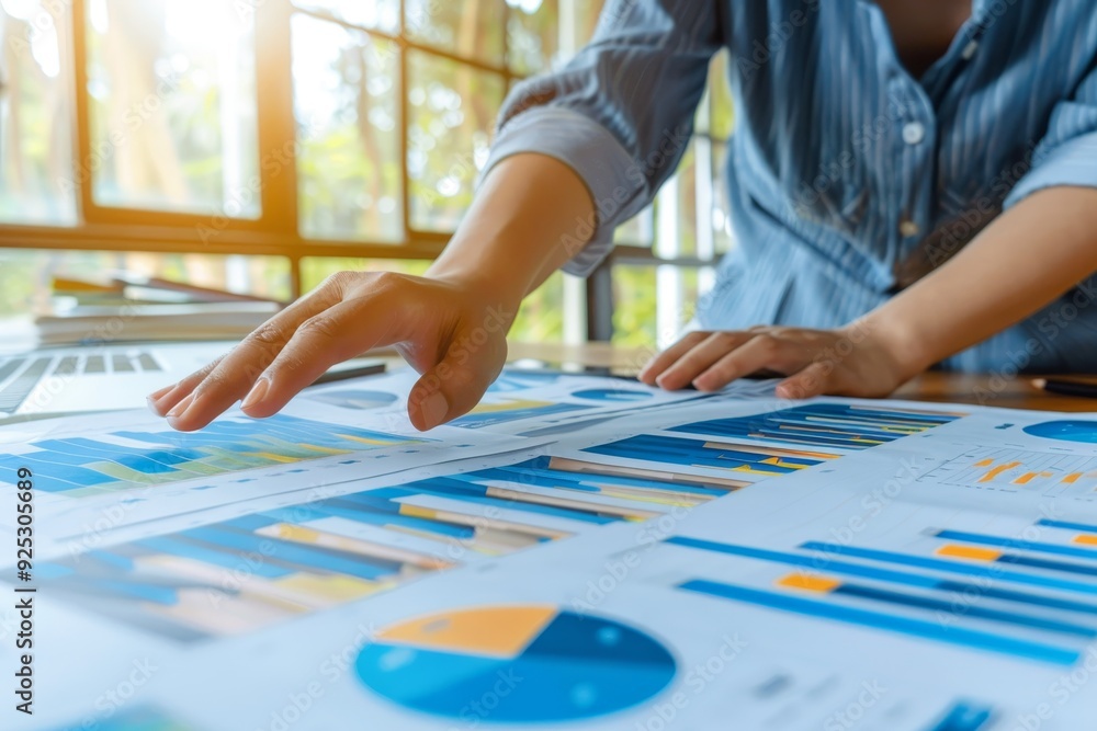 Poster a person pointing at a chart placed on a table, discussing data and analytics, reflect on the signif