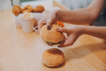 Binge eating disorder concept with woman eating fast food burger, fired chicken , donuts and desserts