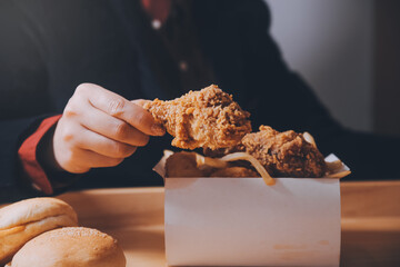close up focus woman hand hold fried chicken for eat,girl with fast food concept