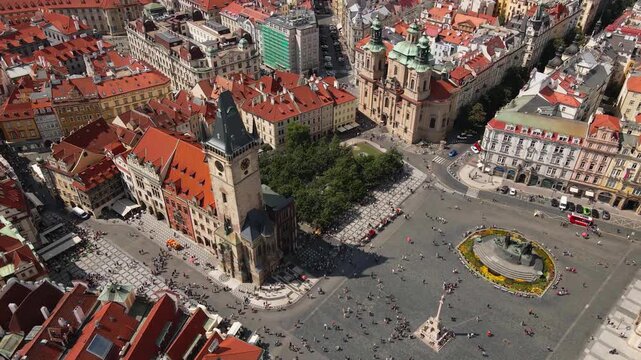 Aerial drone footage captures Prague's Old Town Square, highlighting historic landmarks like the Old Town Hall, the Church of St. Nicholas, and the Jan Hus Monument, surrounded by colorful rooftops.