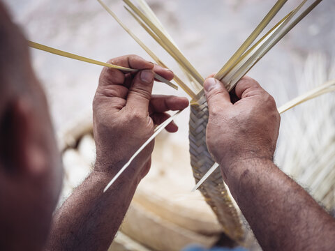 Artisan crafting traditional palmito basket by hand