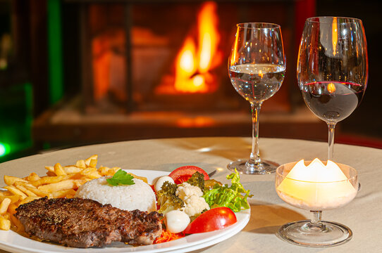 File mignon servido com arroz, batatas fritas e salada . Harmoniza com vinho tinto malbec