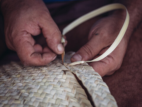 Close-up of hands crafting traditional palmito basket