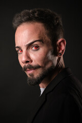 Fototapeta premium Mysterious Man with Red Eyes in Dark Ambience and red contact lenses