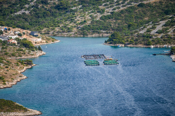 Aerial view of fish and shell farm deep in the blue bay next to the town of Primosten, Croatia