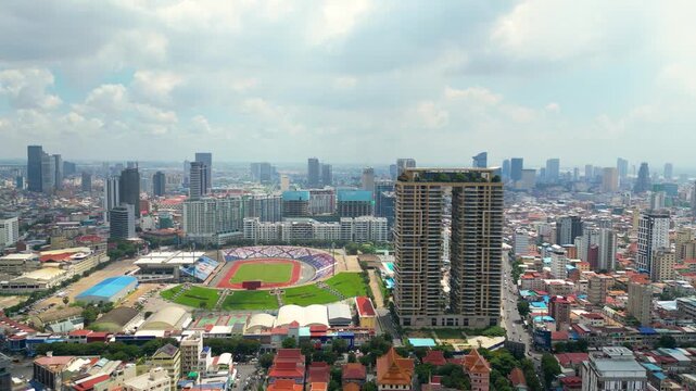Aerial view of multipurpose Olympic Stadium in Phnom Penh city surrounded by urban skyline and condominium complex, Densely populated urban city view