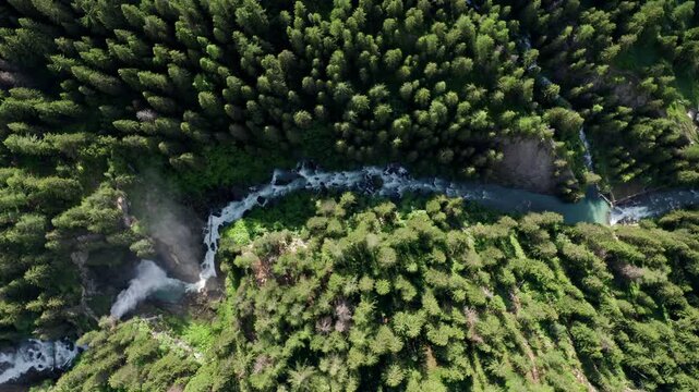 Cascate del rutor waterfall surrounded by lush green forest, aerial view