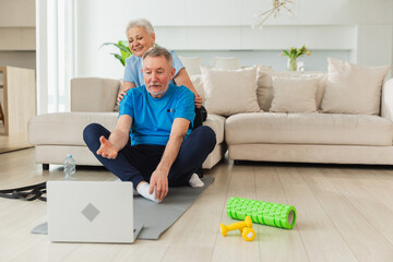 Yoga mindfulness meditation. Senior adult mature couple practicing yoga with online lessons in...