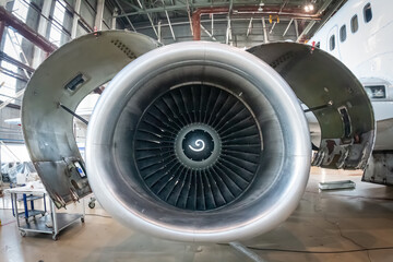 Close-up of an open high bypass turbofan aircraft engine of a passenger airplane in an aviation hangar
