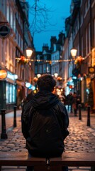 Obraz premium A lone person sits on a bench in a quiet city alley, surrounded by soft street light and decorations, creating a cozy winter evening atmosphere