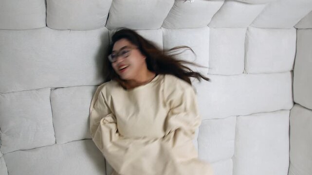 Crazy woman in a straitjacket thrashing on the floor of a padded room. Struggling within a confined cell in an insane asylum