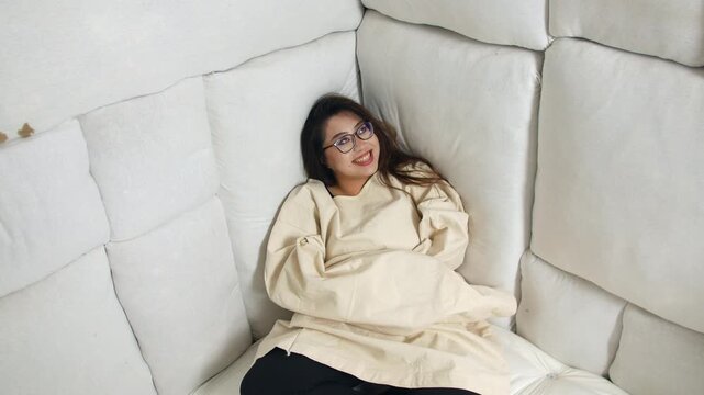 A crazy asian woman in a straight jacket at a mental asylum in a padded cell.
