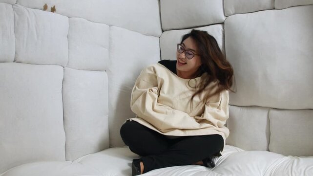 A crazy woman in a straitjacket sitting in a padded room, laughing energetically. The scene captures the intensity of emotions within a mental health care setting