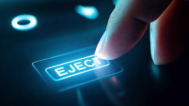 Macro shot of finger pressing a glowing "EJECT" button on an electronics panel.