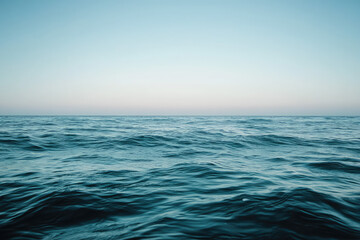 Obraz premium A Tranquil Ocean Horizon: Gentle Waves Caress the Surface Beneath a Vast Clear Sky, Evoking Peace and Reflection in Nature's Embrace.