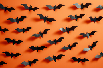 Fototapeta premium Black bats on orange background. Halloween background. Traditional October holiday. Autumn holiday pattern. Happy Halloween card
