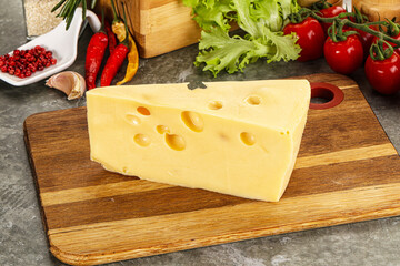 Swiss Maasdam cheese triangle over board
