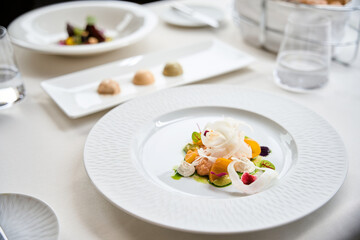 Healthy salad with mango pieces, burrata cheese and herbs on white plate