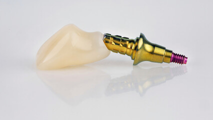 temporary dental crown of the central tooth with a golden color abutment on a white background