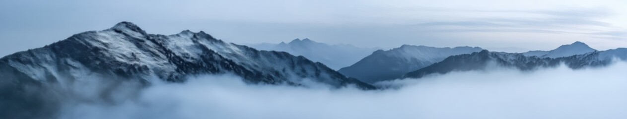 Fototapeta premium Mountains enveloped in fog at noon in a serene landscape