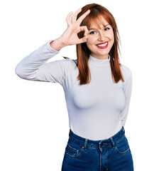 Redhead young woman wearing casual turtleneck sweater smiling positive doing ok sign with hand and fingers. successful expression.