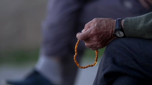an old man holds a Tesbih a traditional Turkish rosary
