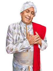 Senior hispanic man wearing tradition sherwani saree clothes smiling with hands on chest with closed eyes and grateful gesture on face. health concept.