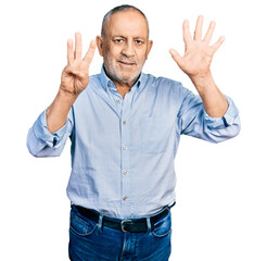 Senior man with grey hair and beard wearing casual blue shirt showing and pointing up with fingers number eight while smiling confident and happy.