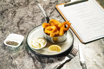Crispy Squid Calamari Rings with Japanese Wasabi Mayonnaise dip, fork and knife served in plate isolated on marble background side view of hong kong food
