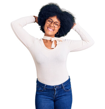 Young african american girl wearing casual clothes and glasses relaxing and stretching, arms and hands behind head and neck smiling happy