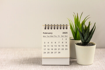 Desk calendar for February 2025 on a gray background with space for copying.