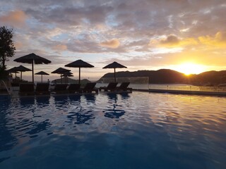 Sunset pool vacation travel umbrella water